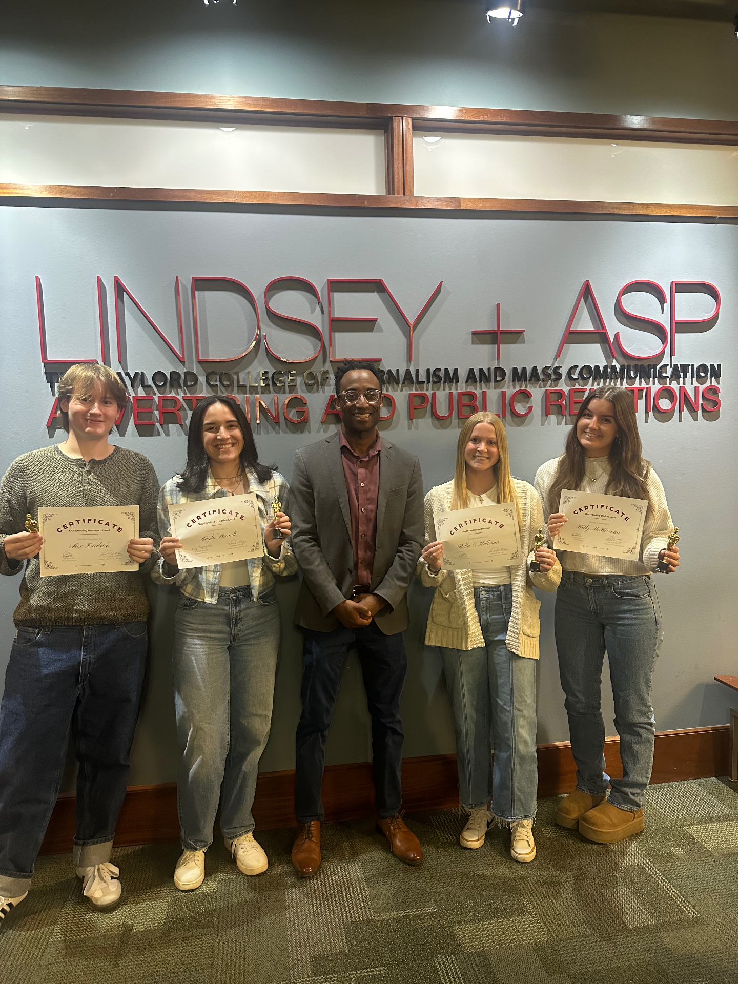 Kayln receiving an Outstanding Creative Lead certificate at Lindsey + ASP